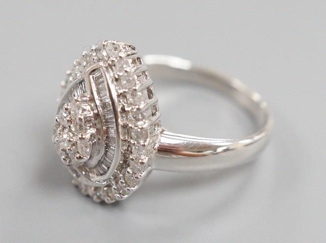 A modern 14ct white gold, baguette and round cut diamond cluster set pear shaped dress ring, size R/S, gross weight 6.7 grams